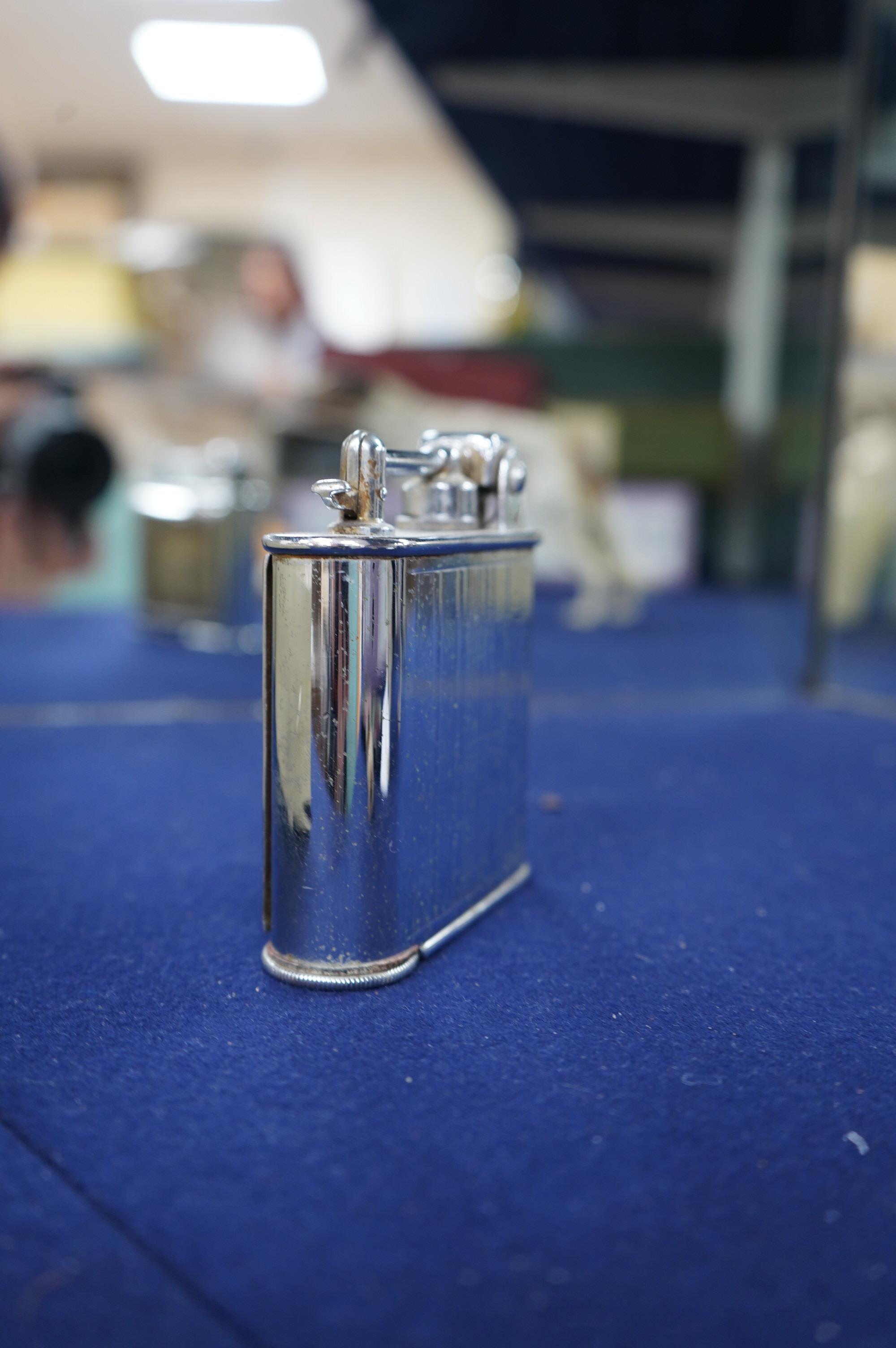 A Lancel Automatique table lighter incorporating an eight day timepiece, 9.5cm high. Condition - fair, some discolouration to the dial.